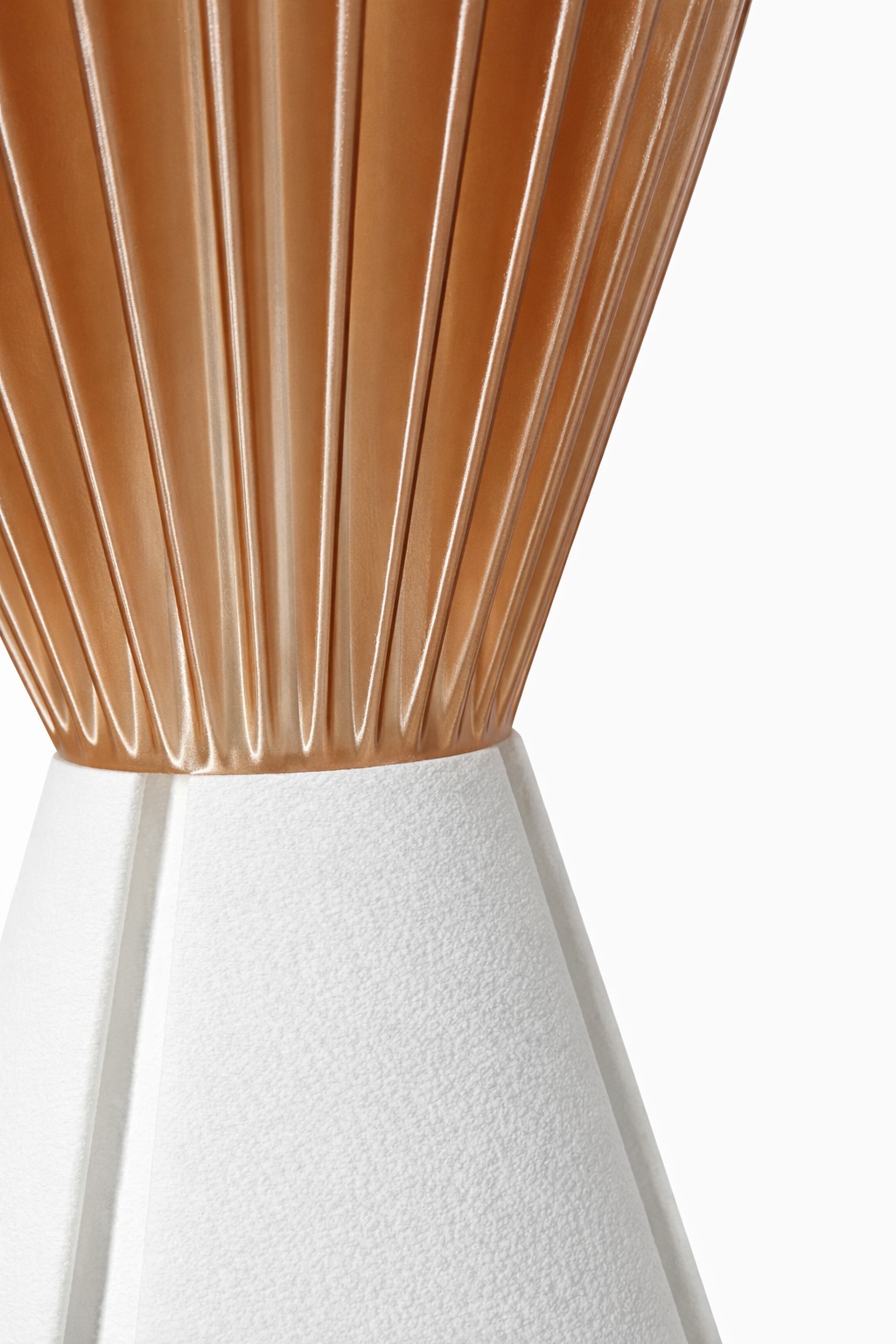 Close up of Sakumi lamp showing fluted copper shade meeting textured white base